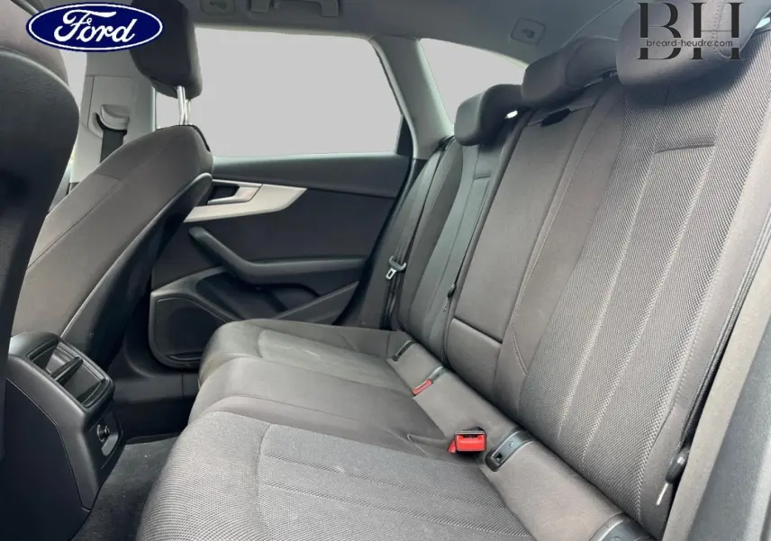 Vue intérieure arrière côté droit de l’Audi A4 Avant 30 TDI gris Manhattan, montrant la banquette tissu et les appuie-têtes.
