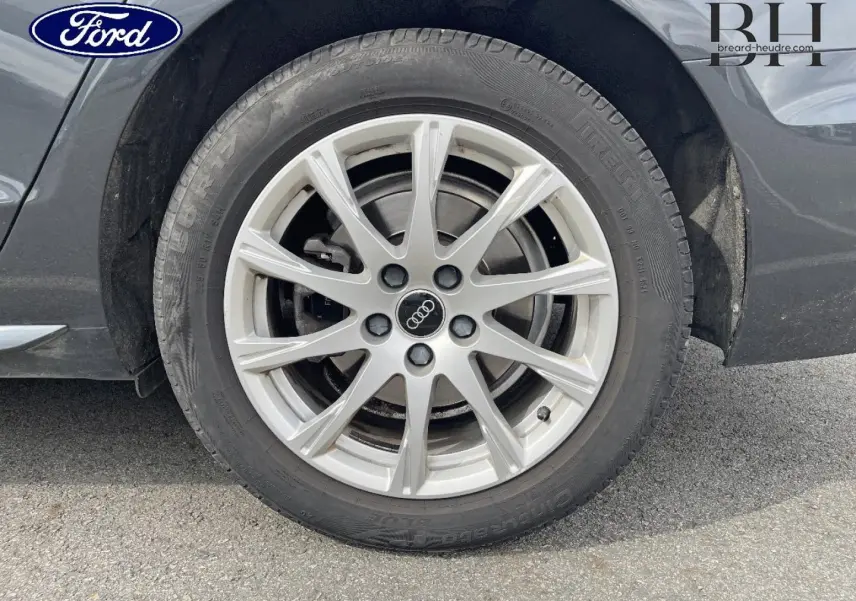 Gros plan sur la roue avant droite d'une Audi A4 Avant gris Manhattan métallisé avec jante alu à 10 branches.