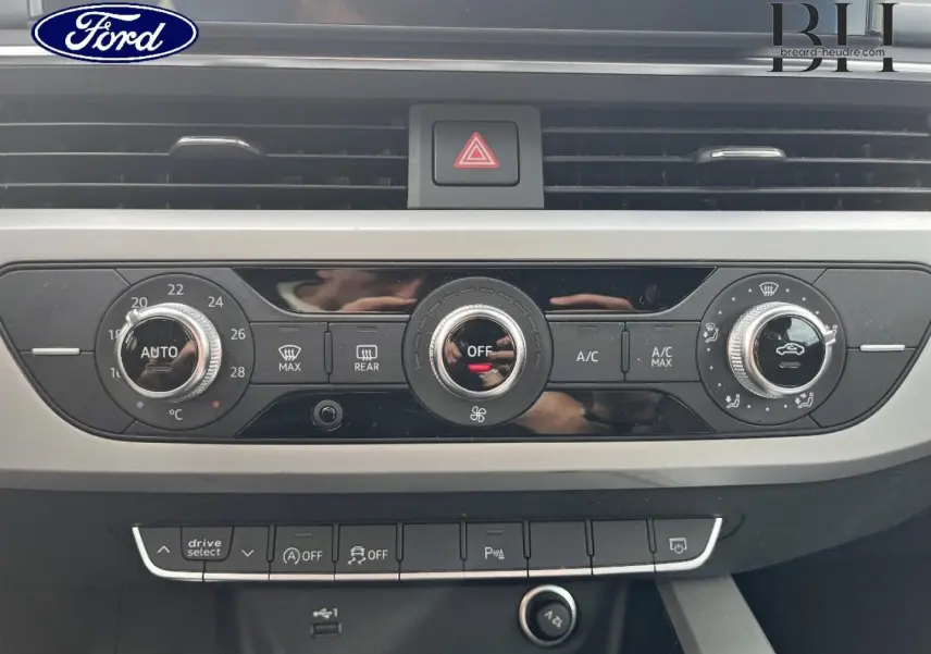 Tableau de bord gris avec commandes climatisation et boutons multifonctions, vue frontale intérieure d'une Audi A4 Avant 2022.