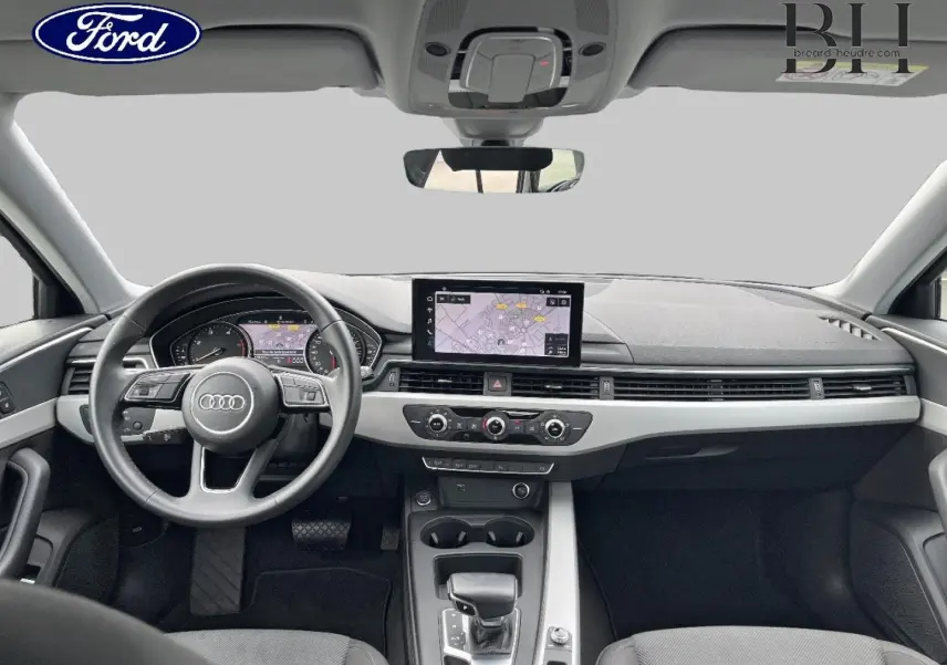 Vue intérieure frontale de l'Audi A4 Avant 30 TDI 2022, tableau de bord gris avec écran GPS central et volant multifonction.