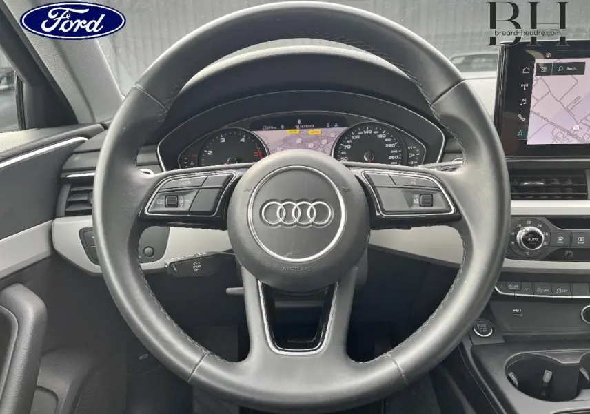 Vue centrée sur le volant cuir noir et tableau de bord numérique de l'Audi A4 Avant 30 TDI 2022.