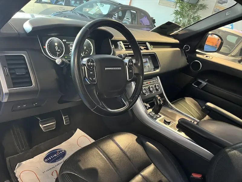 Intérieur noir du Range Rover Sport 2018, vue côté conducteur sur le tableau de bord et volant multifonction.