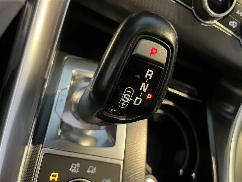 Le levier de vitesse noir en position parking du Range Rover Sport blanc, avec commandes visibles autour.