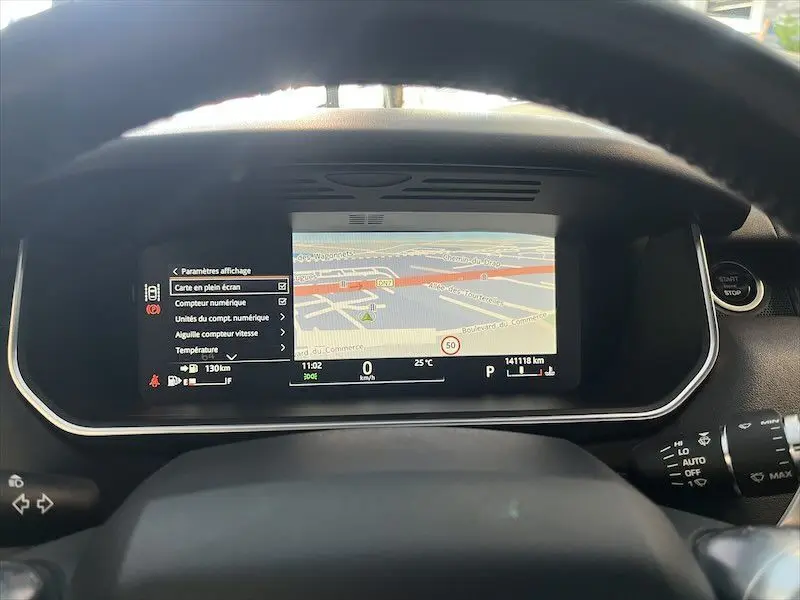 Tableau de bord du Range Rover Sport blanc 2018 avec écran numérique affichant une carte de navigation en plein écran.