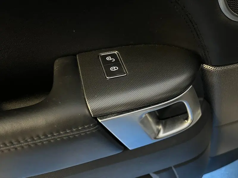Gros plan sur la poignée intérieure noire et les boutons de verrouillage de porte du Range Rover Sport 2018.
