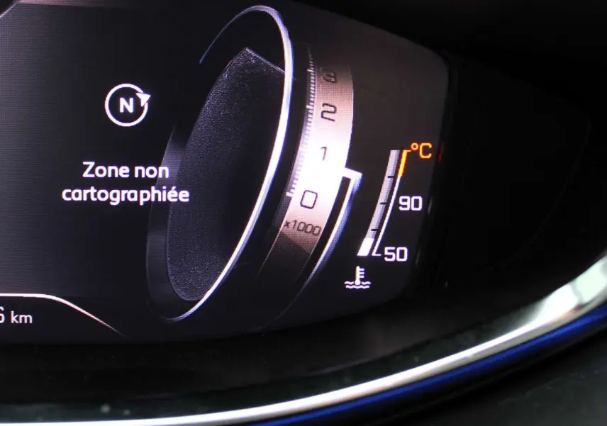 Gros plan sur le tableau de bord numérique du Peugeot 3008 2025, affichant une zone non cartographiée et la température moteur.