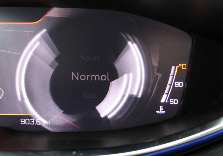 Gros plan sur le tableau de bord numérique du Peugeot 3008 blanc nacré, affichant le mode de conduite "Normal" et la température moteur.