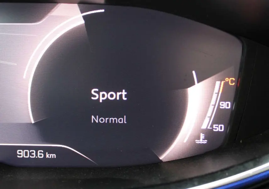 Affichage numérique du tableau de bord Peugeot 3008 2025 montrant le mode Sport et la température moteur, intérieur noir.