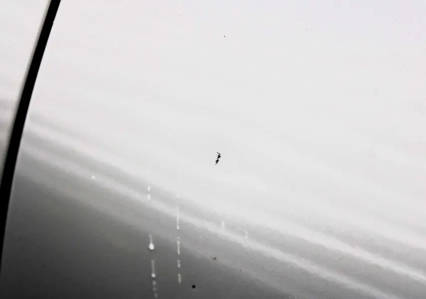 Gros plan sur la peinture blanc nacré du côté gauche d'un Peugeot 3008 2025 avec toit panoramique ouvrant.