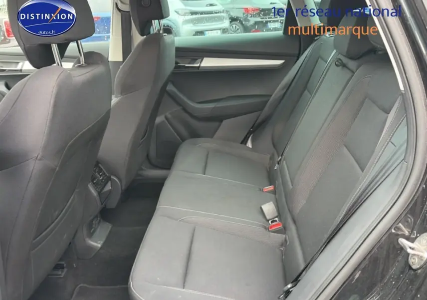 Vue intérieure côté droit des sièges arrière noirs d'un Skoda Karoq 2025 avec porte ouverte et garnitures grises.