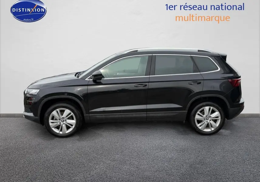 Vue de profil côté gauche d'un Skoda Karoq noir 2025 avec jantes alu et barres de toit visibles.