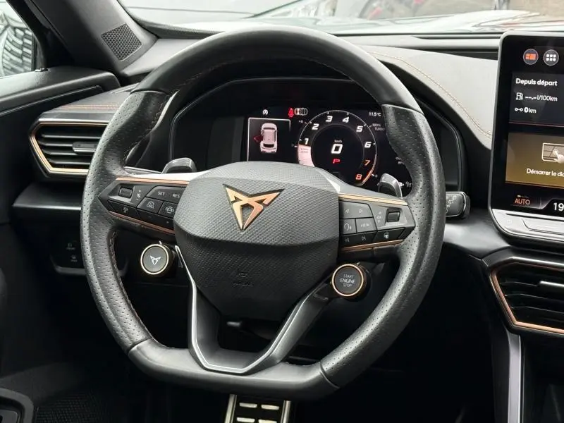 Vue rapprochée du volant perforé noir avec logo CUPRA cuivré et tableau de bord numérique du Formentor gris mat 2025.