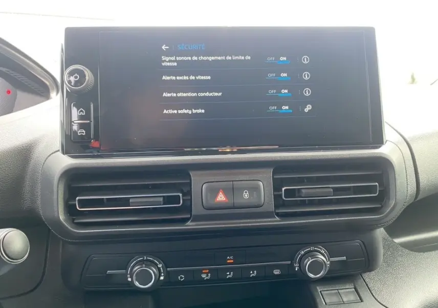 Vue rapprochée du tableau de bord du Peugeot Partner 2024 avec écran tactile affichant les réglages de sécurité.