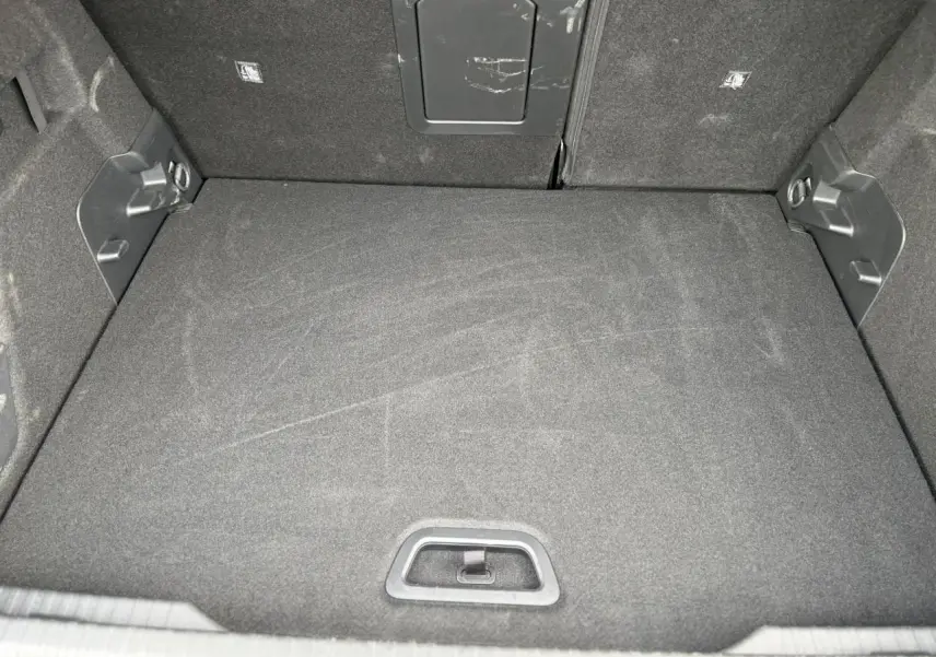 Coffre ouvert de Citroën C4 Hybrid 2025, vue intérieure montrant le tapis de sol noir et la trappe arrière.