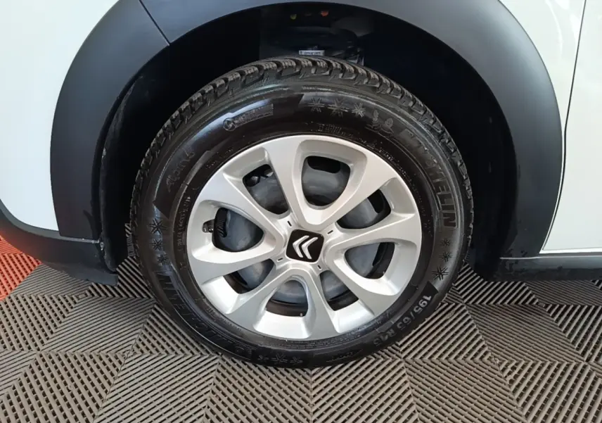Gros plan sur la roue avant droite d'une Citroën C3 blanche avec jante alliage et pneu Michelin.