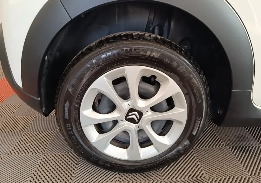 Gros plan sur la roue avant droite blanche d'une Citroën C3 2019 avec jante argentée et logo Citroën central.