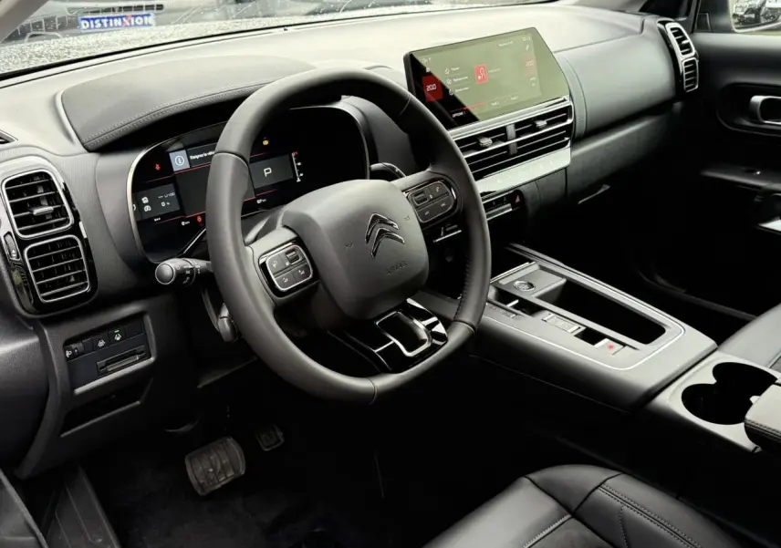 Intérieur avant droit du Citroën C5 Aircross Hybrid 2025 avec volant cuir, écran tactile 10 pouces et finition Urban Black.