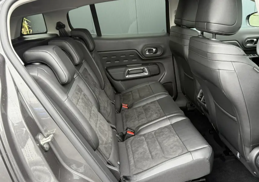 Vue côté gauche des sièges arrière noirs en Alcantara et tissu effet cuir du Citroën C5 Aircross Hybrid 2025.
