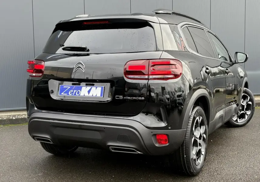 Vue 3/4 arrière droite d'un Citroën C5 Aircross Hybrid noir Perla avec jantes bi-ton et feux arrière LED 3D.