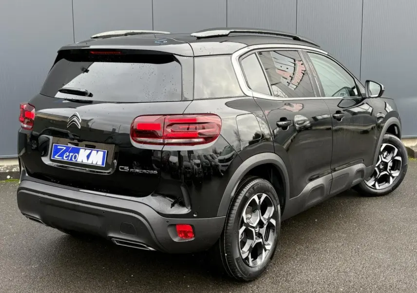Vue 3/4 arrière droit d'un Citroën C5 Aircross Hybrid noir Perla avec jantes alliage bi-ton et vitres surteintées.