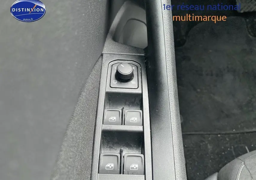 Gros plan sur les commandes de lève-vitres et réglage des rétroviseurs côté conducteur d’un Skoda Kamiq noir.