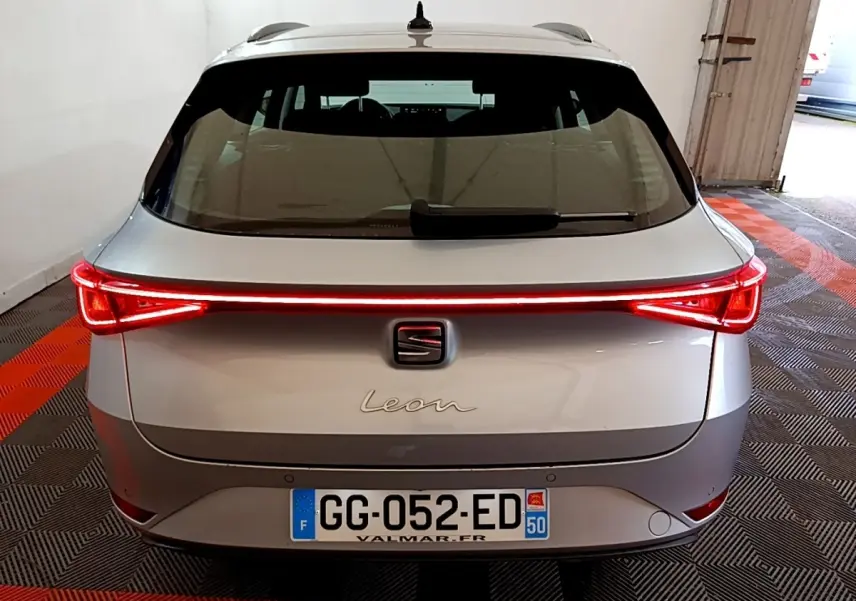 Vue arrière d'une SEAT Leon gris clair avec feux arrière LED allumés dans un garage.