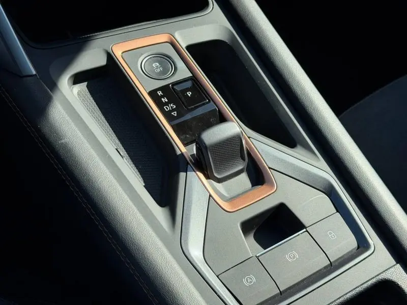 Gros plan sur la console centrale du CUPRA Formentor 2025, levier de vitesse automatique avec cadre cuivré et boutons de contrôle.