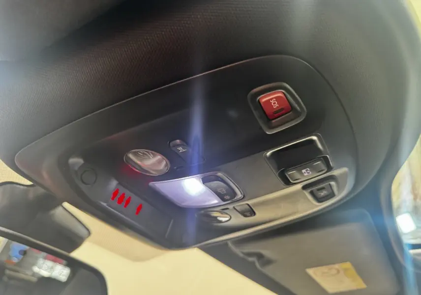 Vue intérieure en gros plan du plafonnier avec commandes d’éclairage et bouton SOS dans une Peugeot 308 noire.