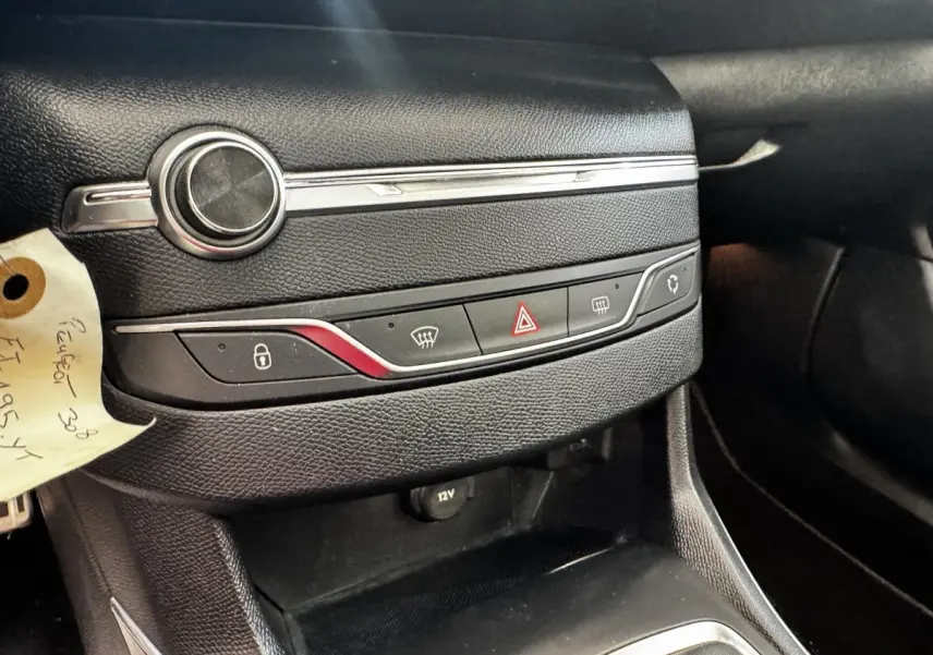 Détail de la console centrale noire de la Peugeot 308 2018 avec commandes de verrouillage et dégivrage, prise 12V visible.