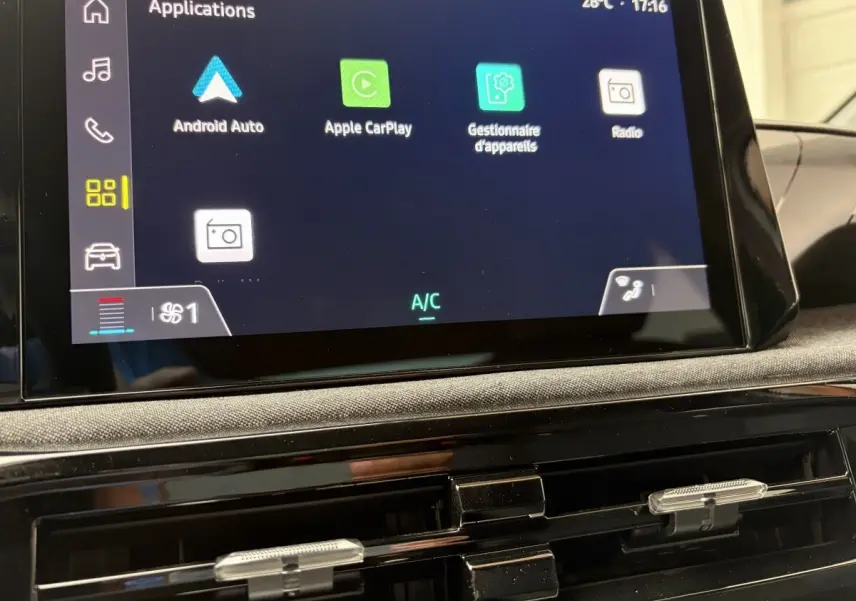 Écran tactile central de la Renault Clio blanche 2026 montrant les applications Android Auto et Apple CarPlay, vue intérieure frontale.