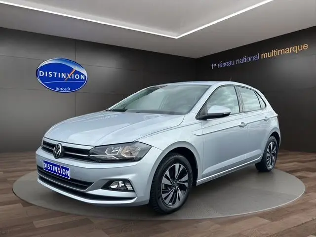 Volkswagen Polo VI Lounge Business gris vue 3/4 avant droit en showroom avec jantes alliage et calandre noire.