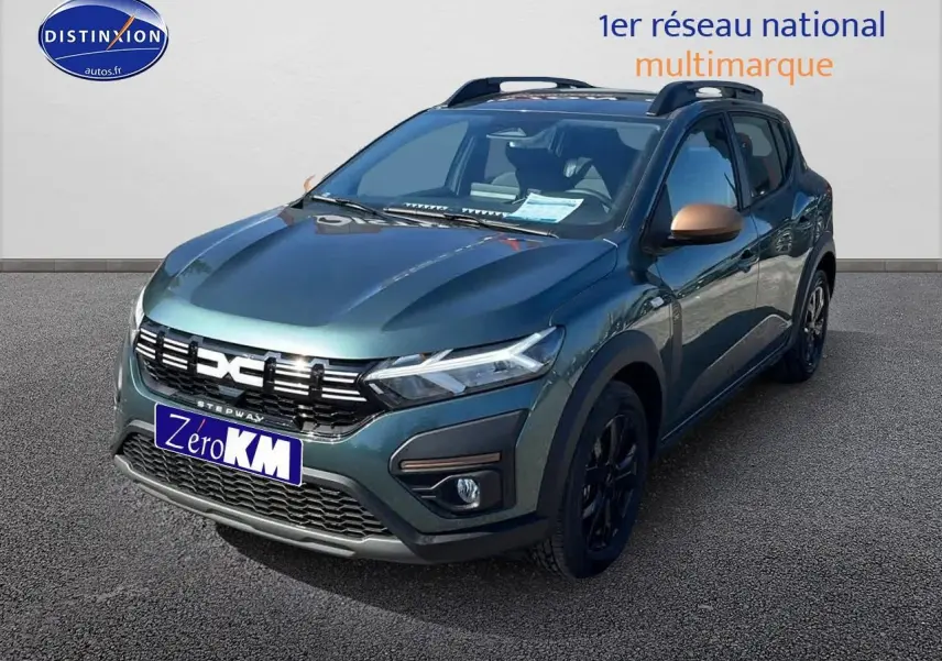 Vue 3/4 avant droite d'une Dacia Sandero Stepway 2025 vert cèdre avec jantes noires et barres de toit.