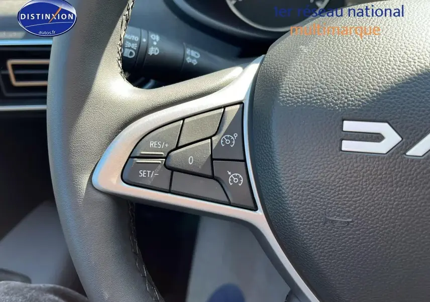 Gros plan sur les commandes de régulateur de vitesse au volant d'une Dacia Sandero 2025 vert cèdre.