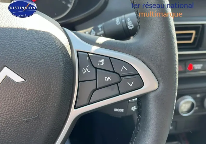 Gros plan sur les commandes au volant à droite du tableau de bord d'une Dacia Sandero 2025.