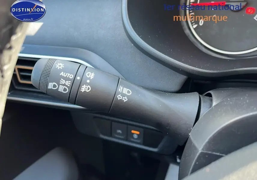 Gros plan sur la commande des phares et clignotants à gauche du volant dans l'habitacle d'une Dacia Sandero 2025.