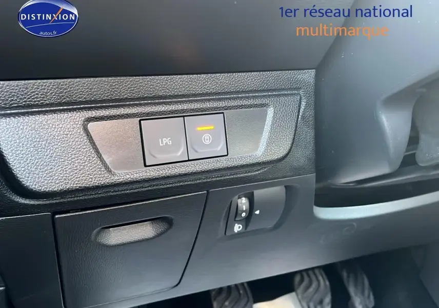 Gros plan sur les commandes LPG et verrouillage, côté gauche du tableau de bord noir de la Dacia Sandero 2025 vert cèdre.