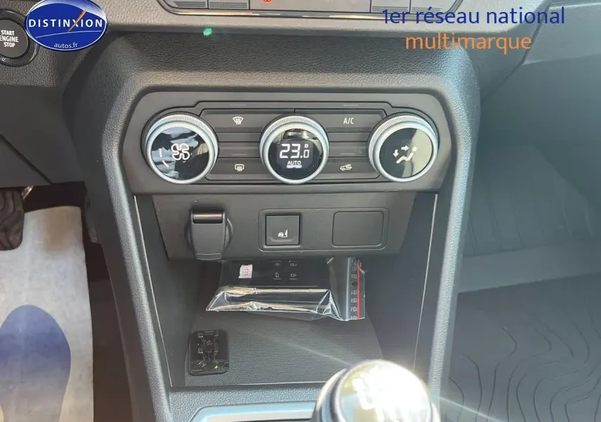 Gros plan sur la console centrale de la Dacia Sandero 2025, avec commandes climatisation et levier de vitesse manuel.