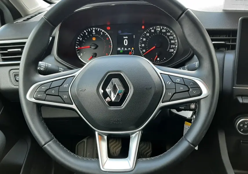 Vue frontale du volant noir de la Renault Clio V 1.0 TCE 90CH Équilibre, avec tableau de bord et compteurs visibles.