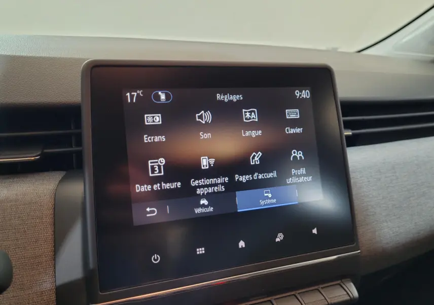 Écran tactile central de la Renault Clio bleu, vue rapprochée du tableau de bord avec menu réglages affiché.