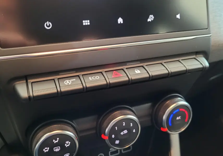 Gros plan sur la console centrale de la Renault Clio Evolution Blue dCi 100 avec commandes climatisation et boutons fonctionnels.