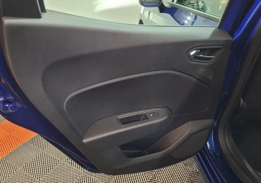 Vue rapprochée de la porte arrière gauche bleu Renault Clio 2025, avec commande de vitre électrique et panneau noir intérieur.
