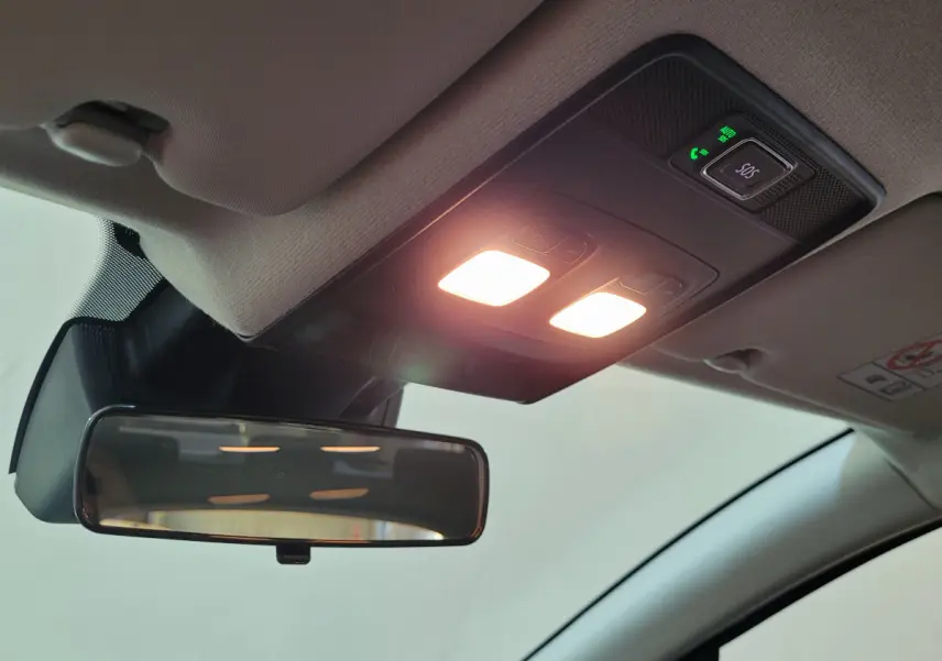 Vue intérieure du plafond avant de la Renault Clio bleu, avec rétroviseur et éclairage de lecture allumé.