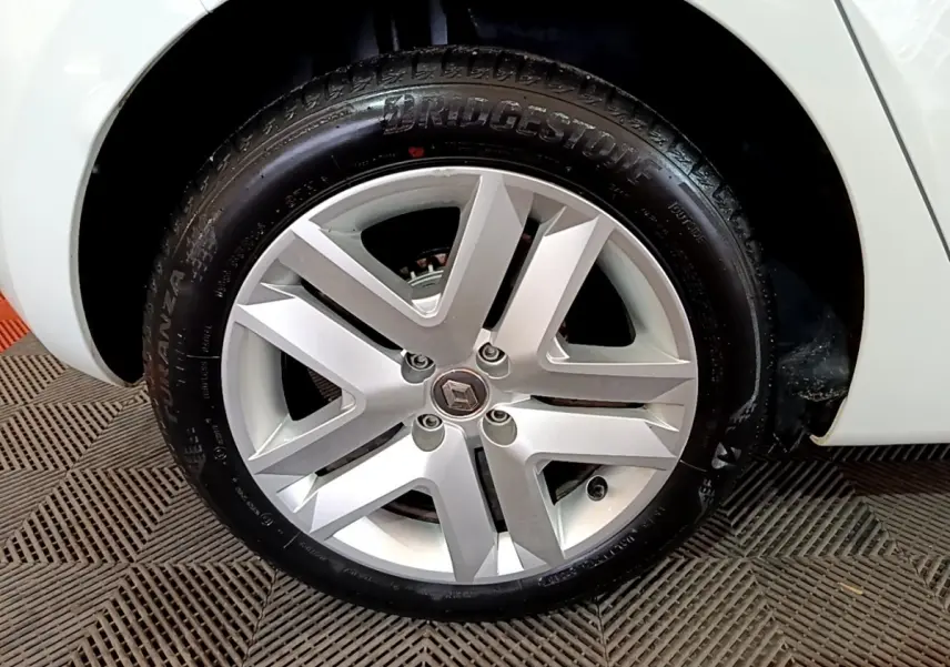 Gros plan sur la roue avant droite blanche d'une Renault Clio Business 2021 avec jante alliage et logo Renault central.