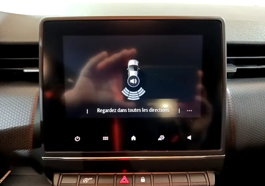 Écran tactile central de la Renault Clio Business blanc 2021 affichant l'alerte de surveillance des angles morts.