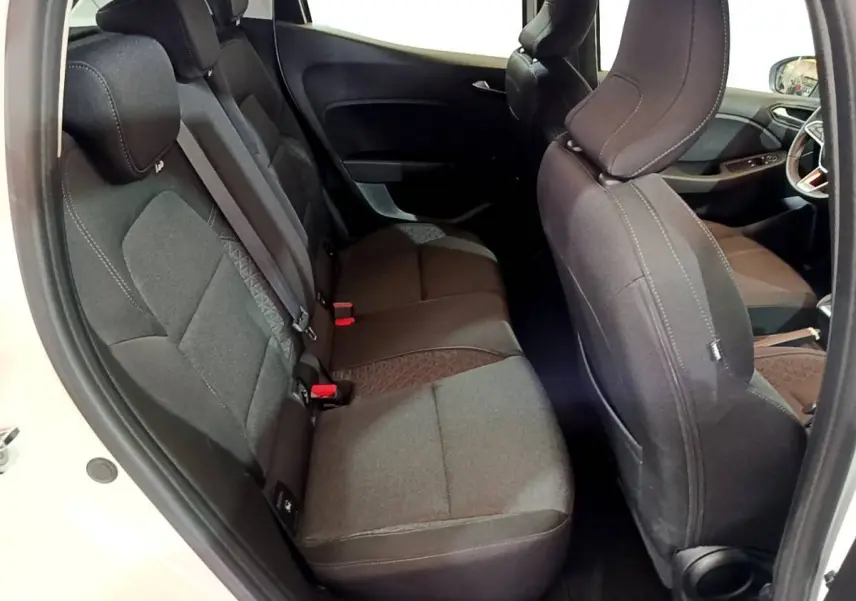 Vue intérieure côté droit montrant les sièges arrière noirs et le siège avant d'une Renault Clio Business blanche.
