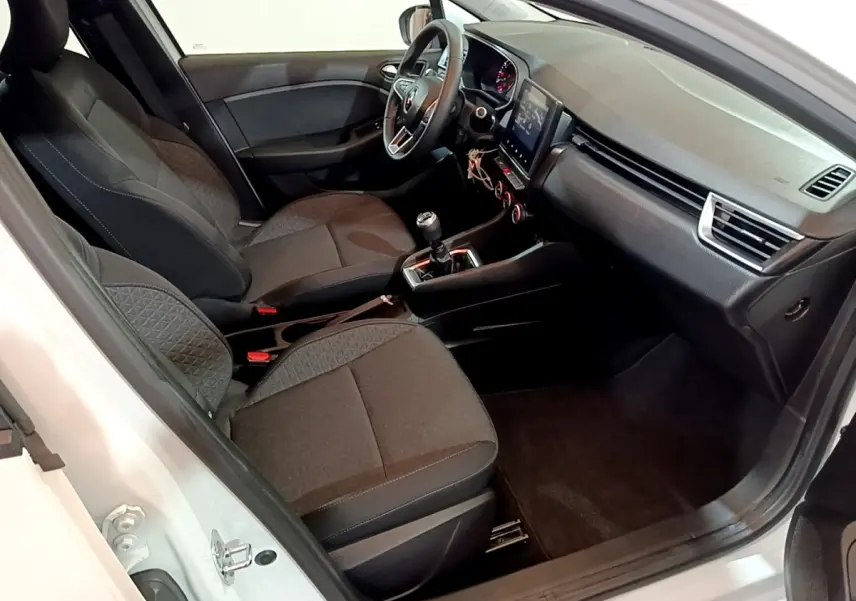 Intérieur de la Renault Clio Business blanc vue côté conducteur, montrant sièges tissu et tableau de bord avec écran tactile.