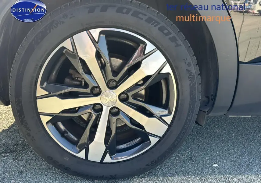 Gros plan sur la jante alu noire et argentée du côté gauche d'un Peugeot 3008 noir métal 2022.