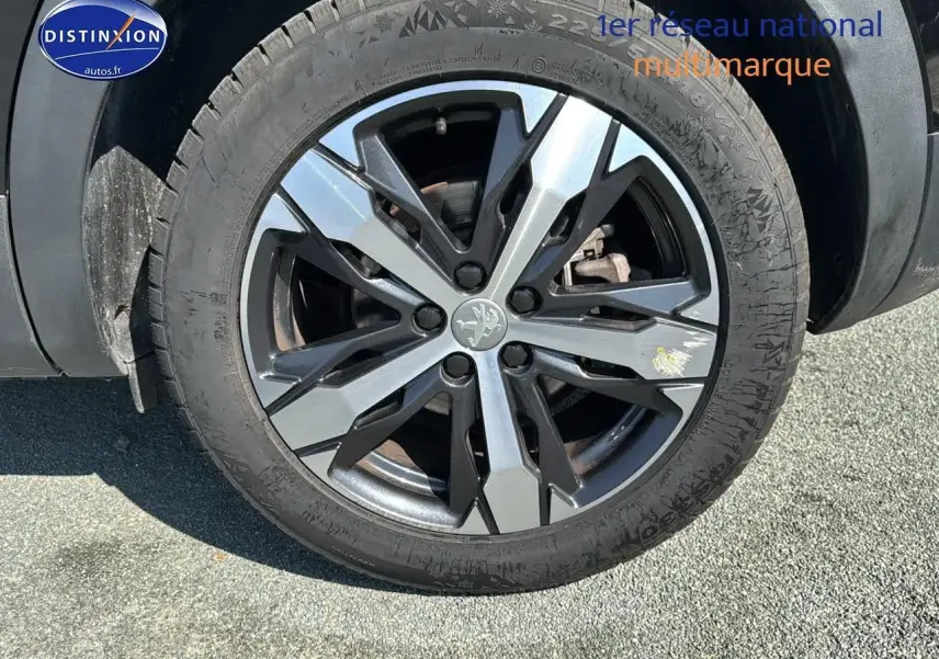 Gros plan sur la jante alu au design moderne du côté avant droit d'un Peugeot 3008 noir métal 2022.