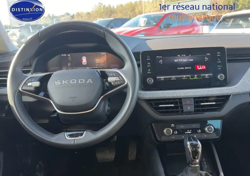 Vue intérieure avant du Skoda Kamiq noir 2025, volant cuir multifonction et écran tactile central allumé.