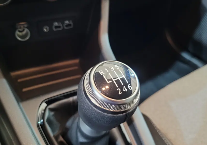 Gros plan sur le levier de vitesses manuel de la Renault Clio Evolution Blue dCi 100, intérieur noir et gris.